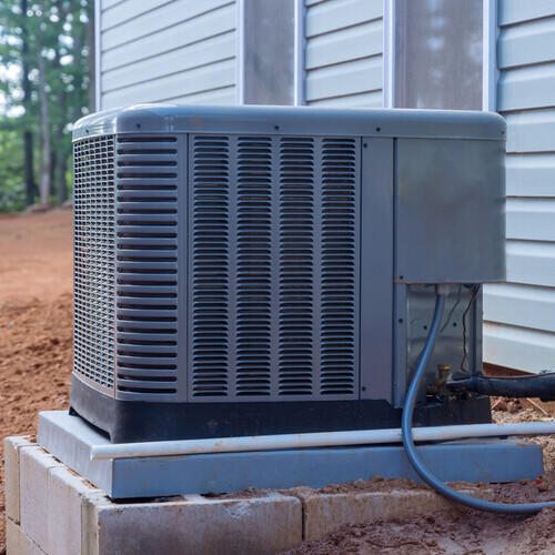 Outside installation of an electric air conditioner on exterior a new home